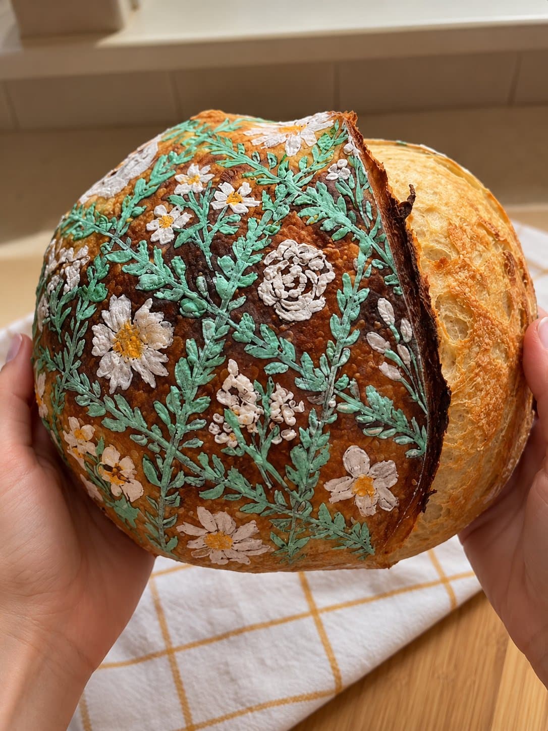 Sauerteigbrot, von Hand mit Blüten und Ranken bemalt
