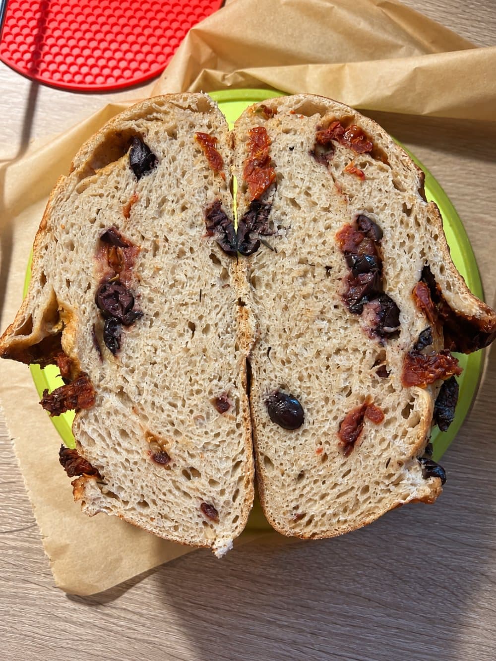 Aufgeschnittenes Sauerteigbrot mit getrockneten Tomaten und Oliven